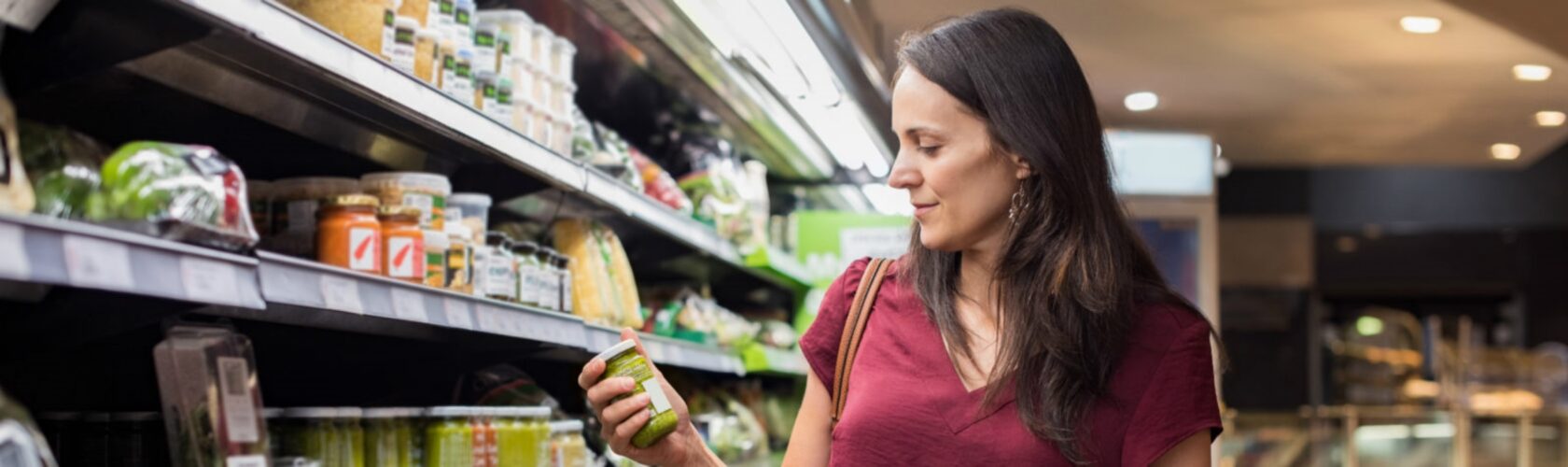 Beeld: vrouw bekijkt product uit het supermarktschap